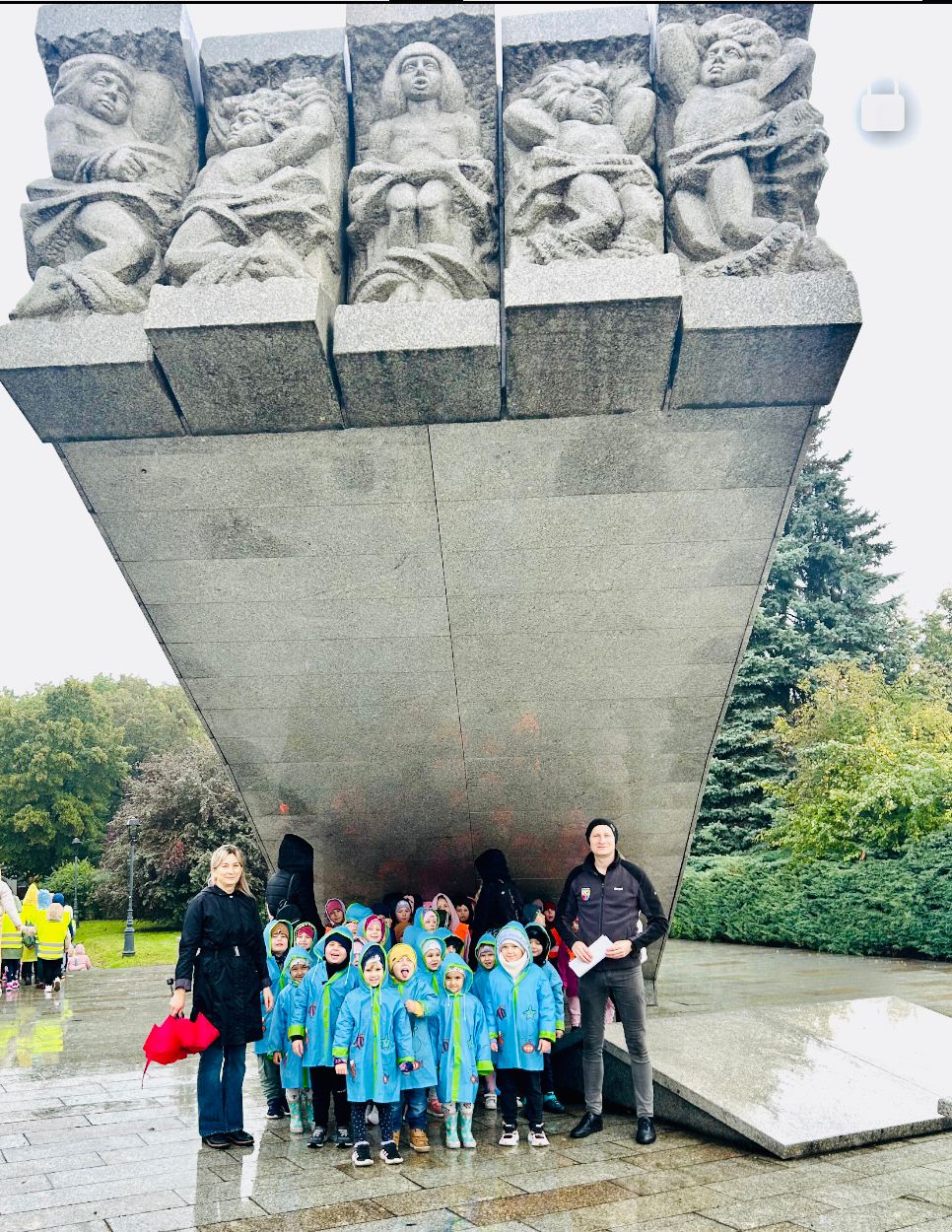  Dzieci stoją pod pomnikie...