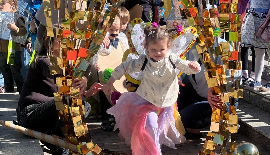 Mała dziewczynka w różowej spódniczce i białej bluzce tańczy
