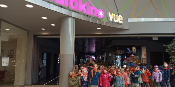 Grupa około 30 dzieci stoi przed wejściem do kina Multikino