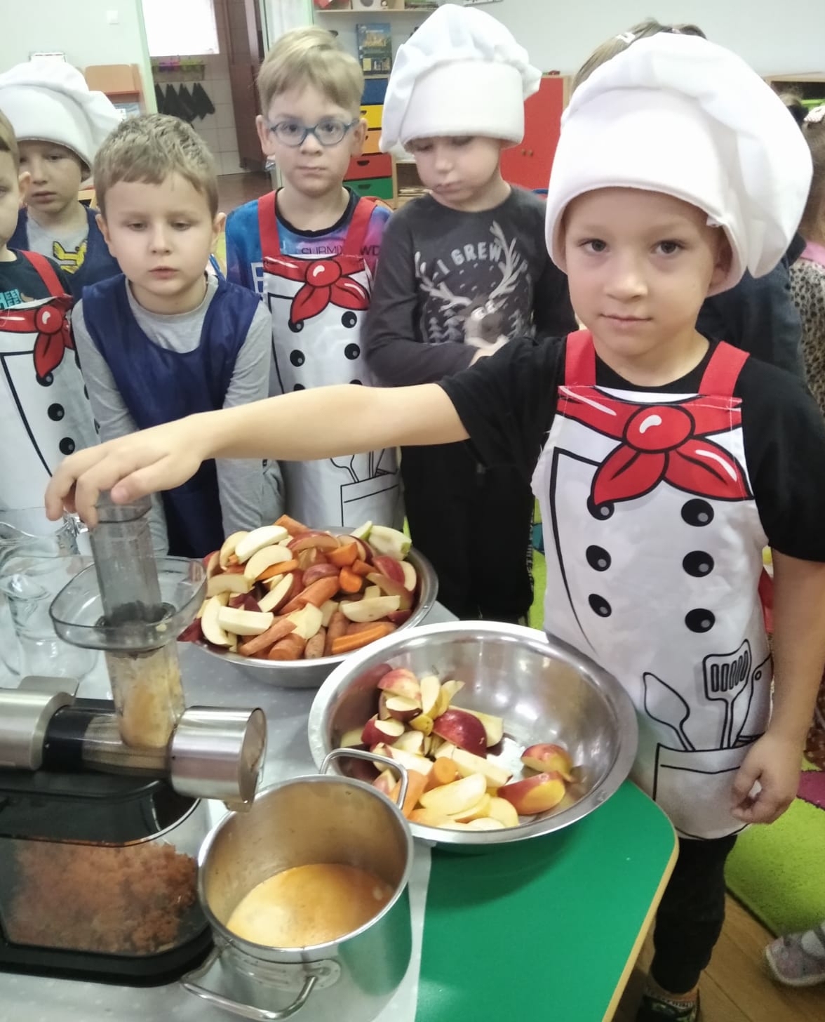 Dzieci przygotowują sok warzywno-owocowy z wykorzystaniem sokowirówki